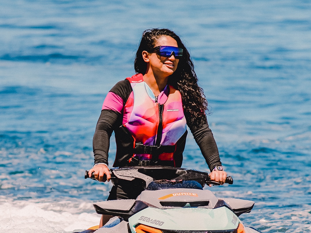 Two women sitting on their respective Sea-Doo personal watercraft talking