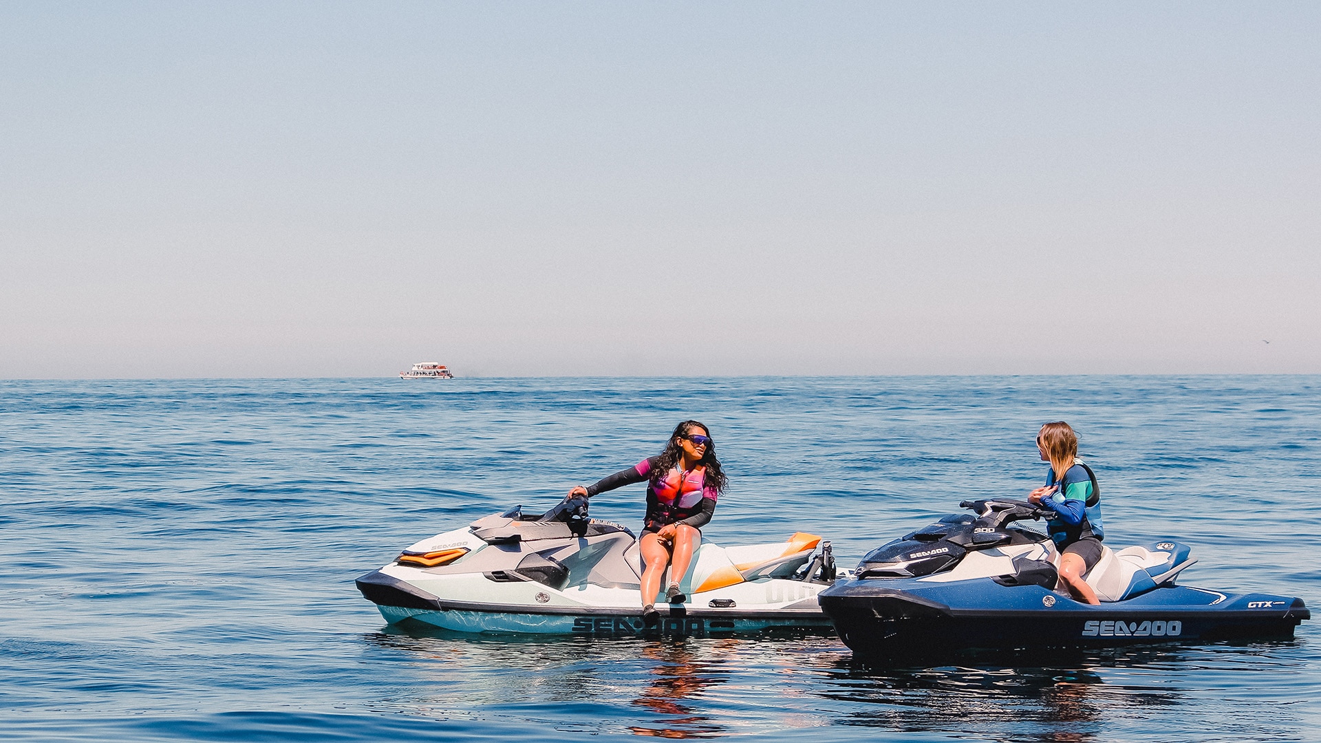 Two women riding Sea-Doo personal watercrafts