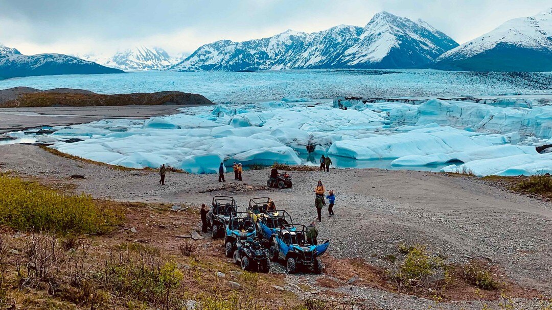 Les gens se rassemblent près des glaciers et des montagnes avec des véhicules tout-terrain.