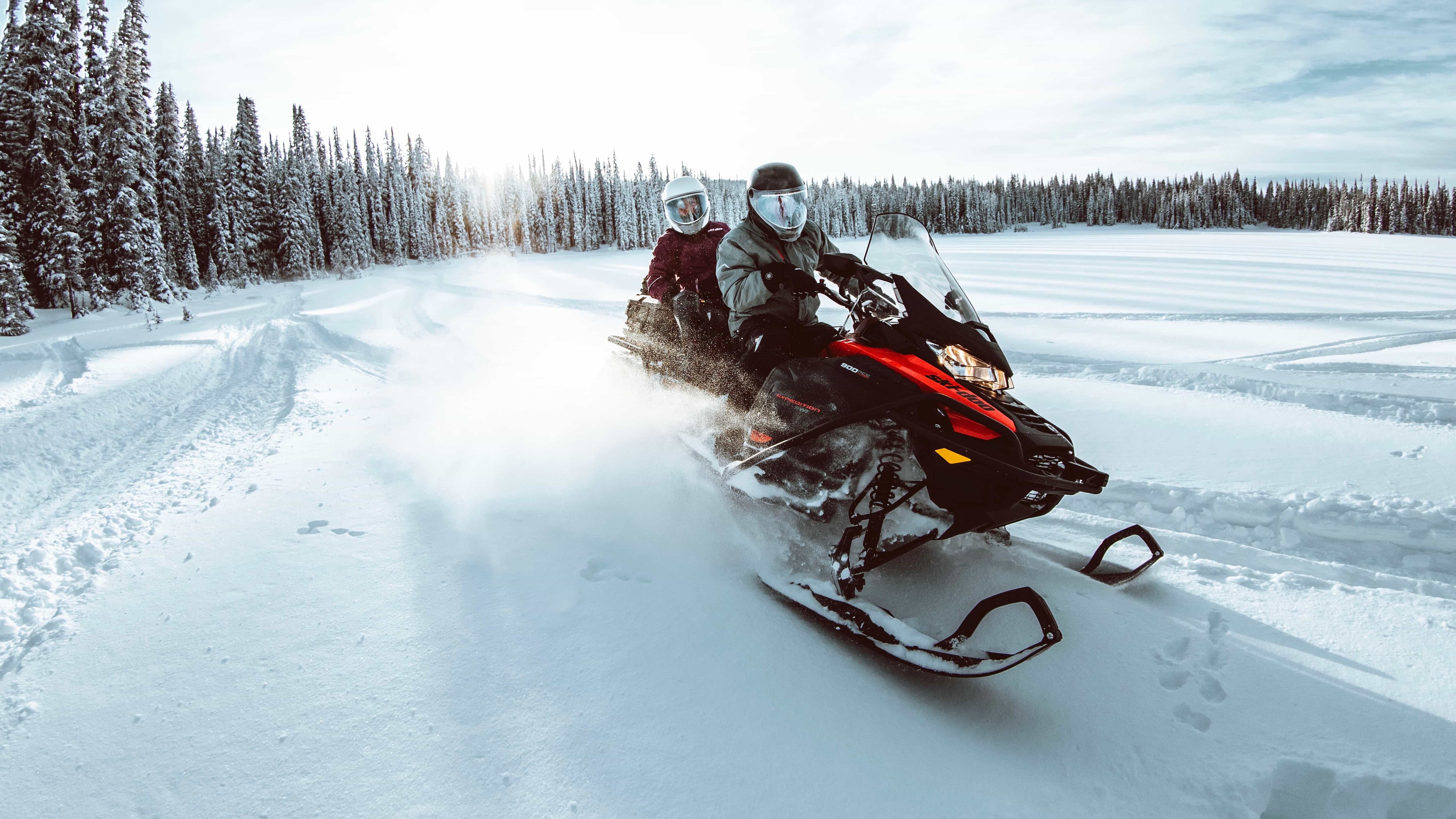 A group of people riding snowmobiles