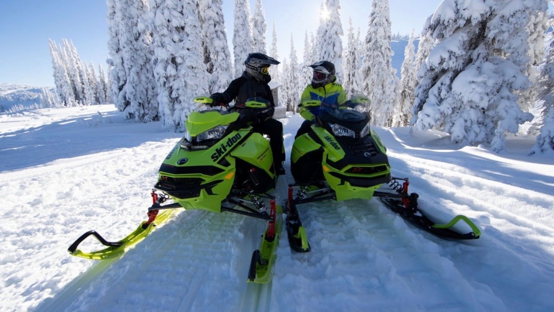 A snowmobilers talking on their Ski-Doo