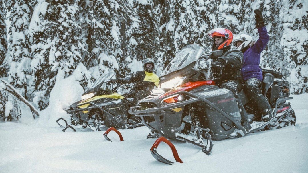 Two snowmobilers talking on their Ski-Doo
