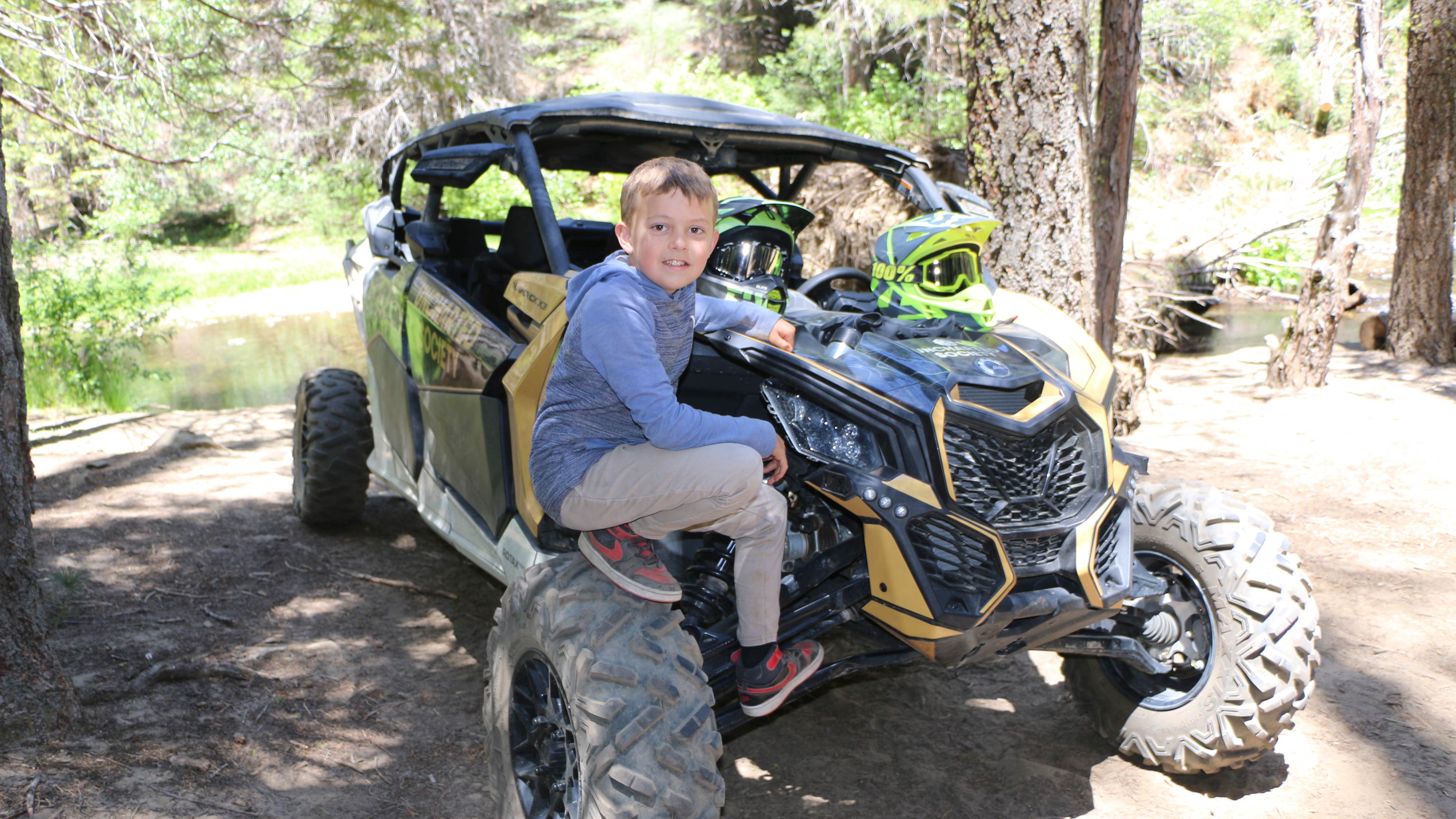 kid sitting on the wheel of a Can-Am