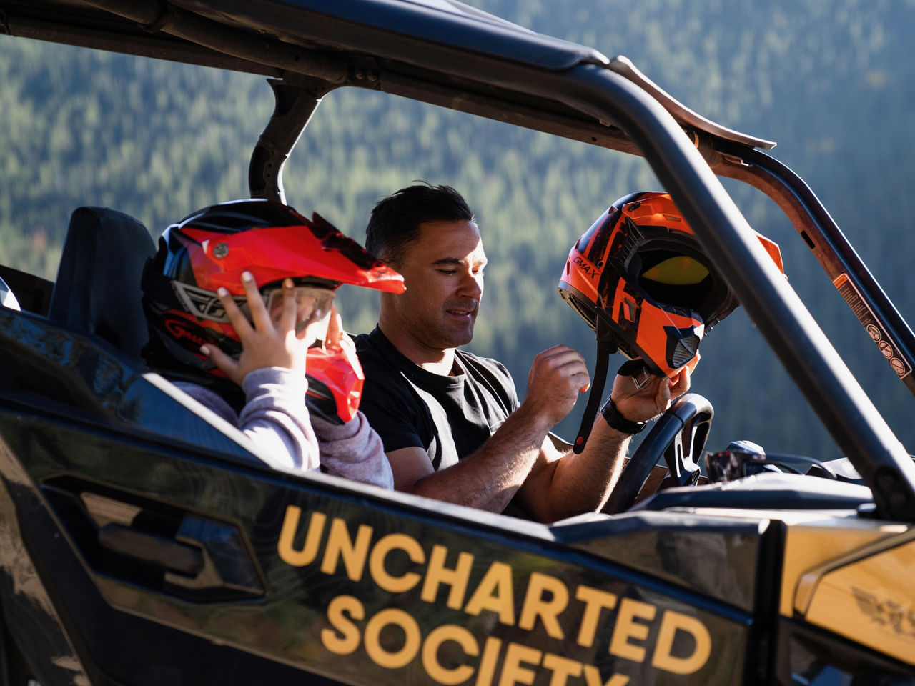 A man wearing his helmet in a off-road vehicle