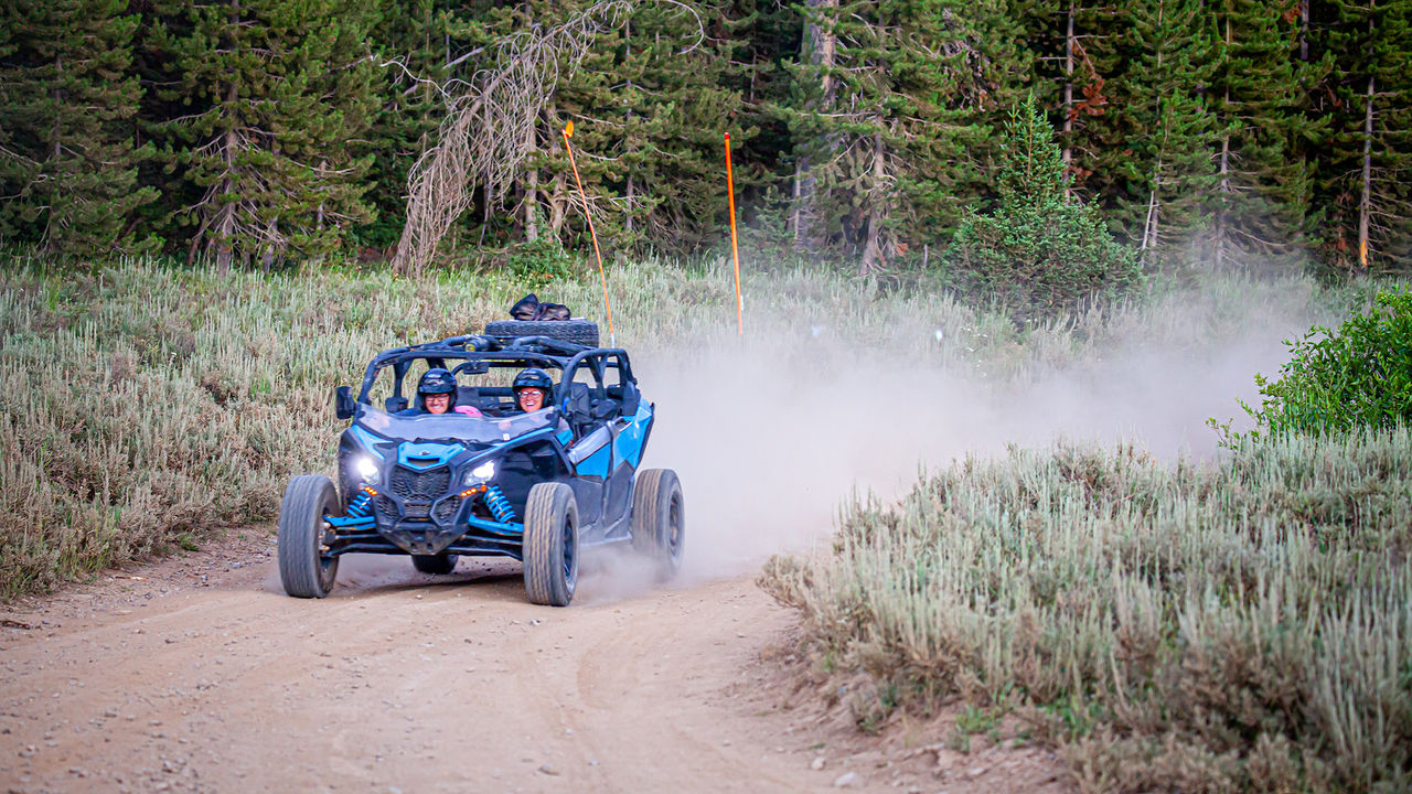 A couple having fun driving a blue side-by-side vehicle