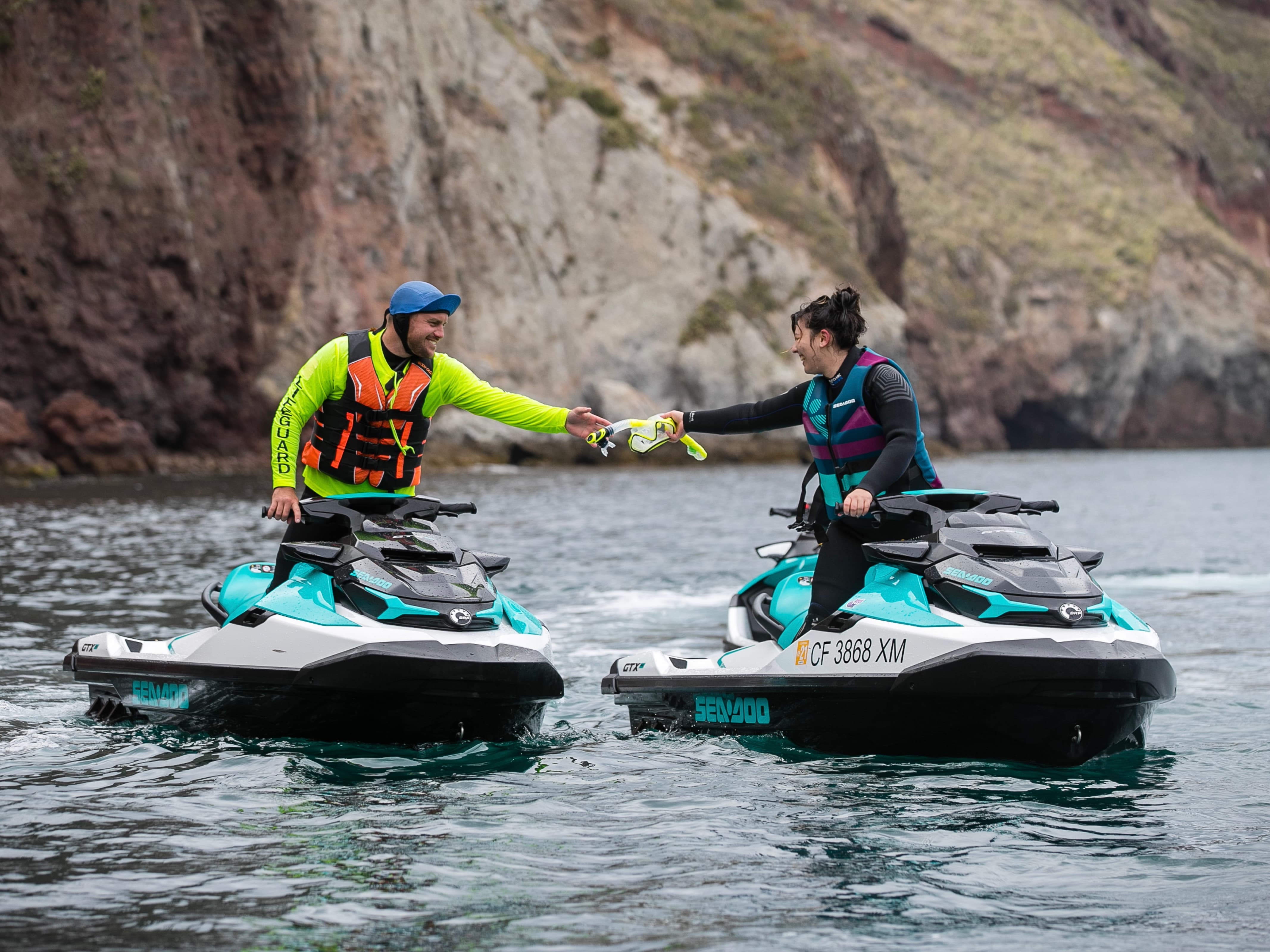 A Sea-Doo guide giving a mask to a women on a Sea-Doo