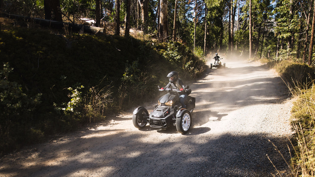 Two riders on Ryker models in a forest