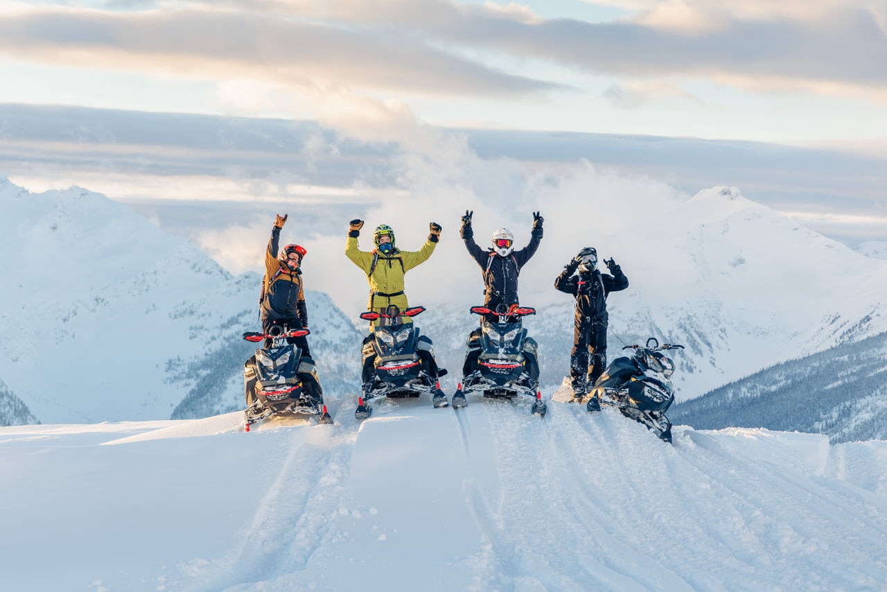 groupe de pilotes de Ski-Doo au sommet de la montagne