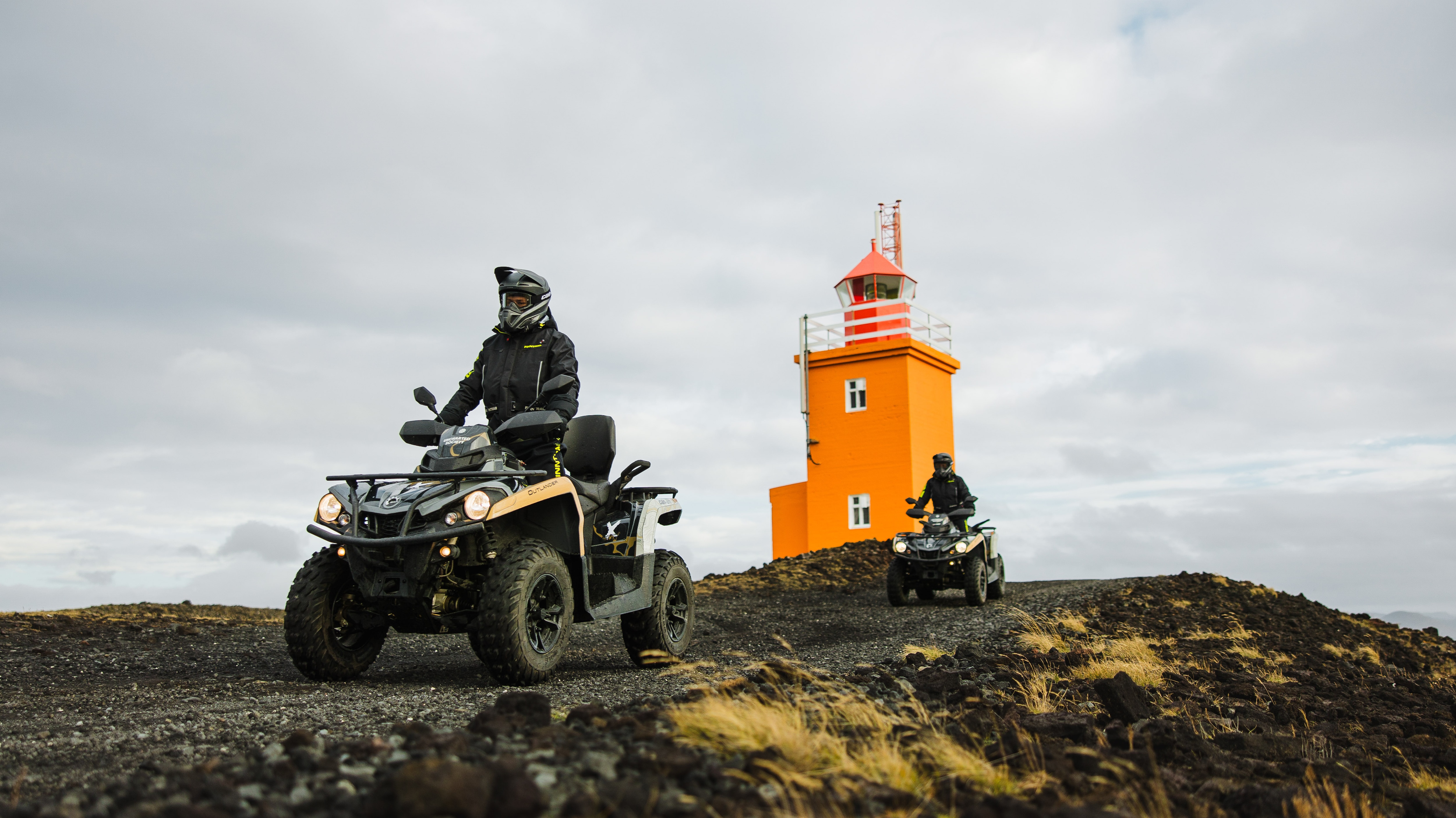 Two Can-Am ATV riding on a dirt road