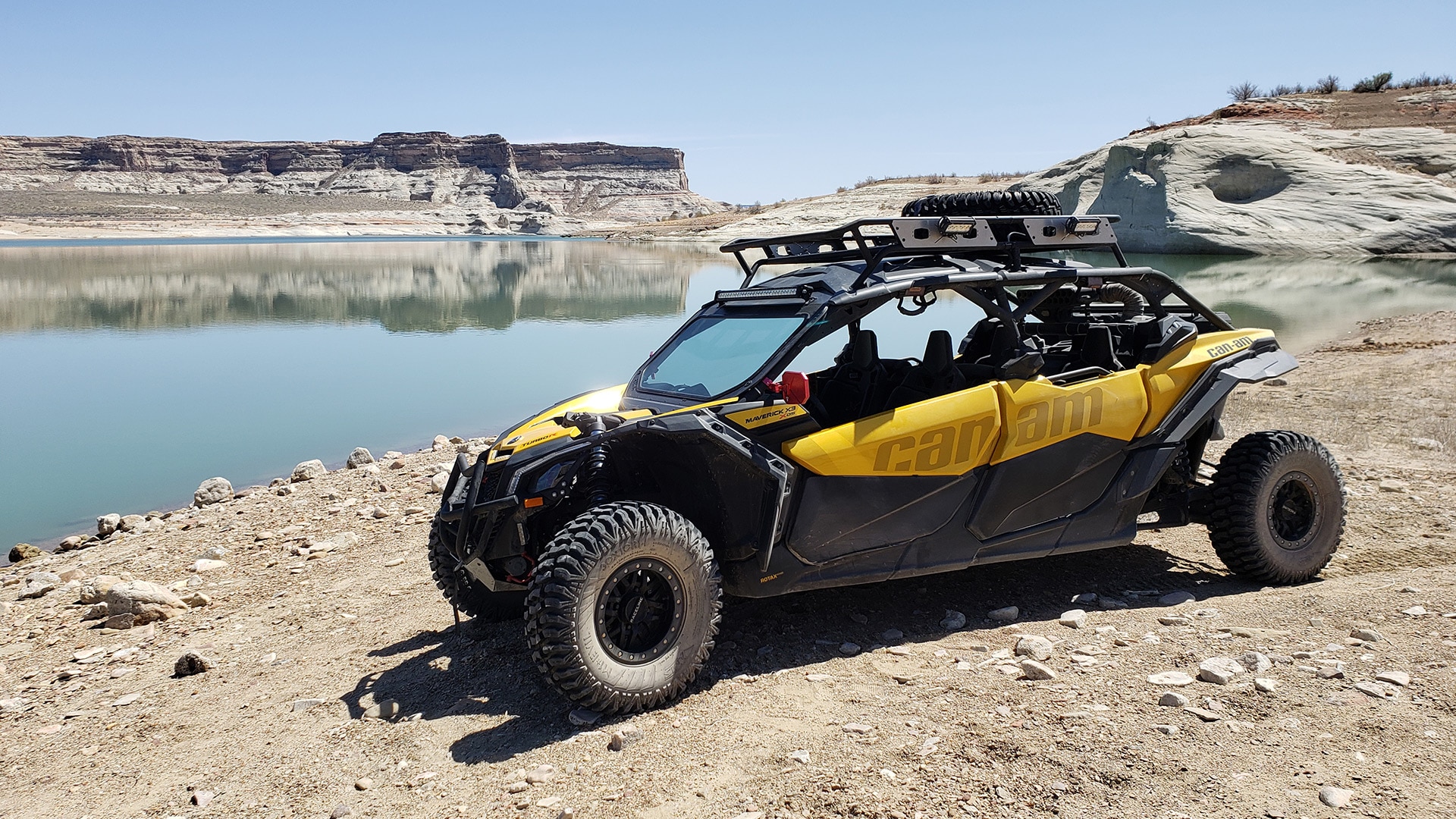 A Can-Am SxS vehicle parked near a lake