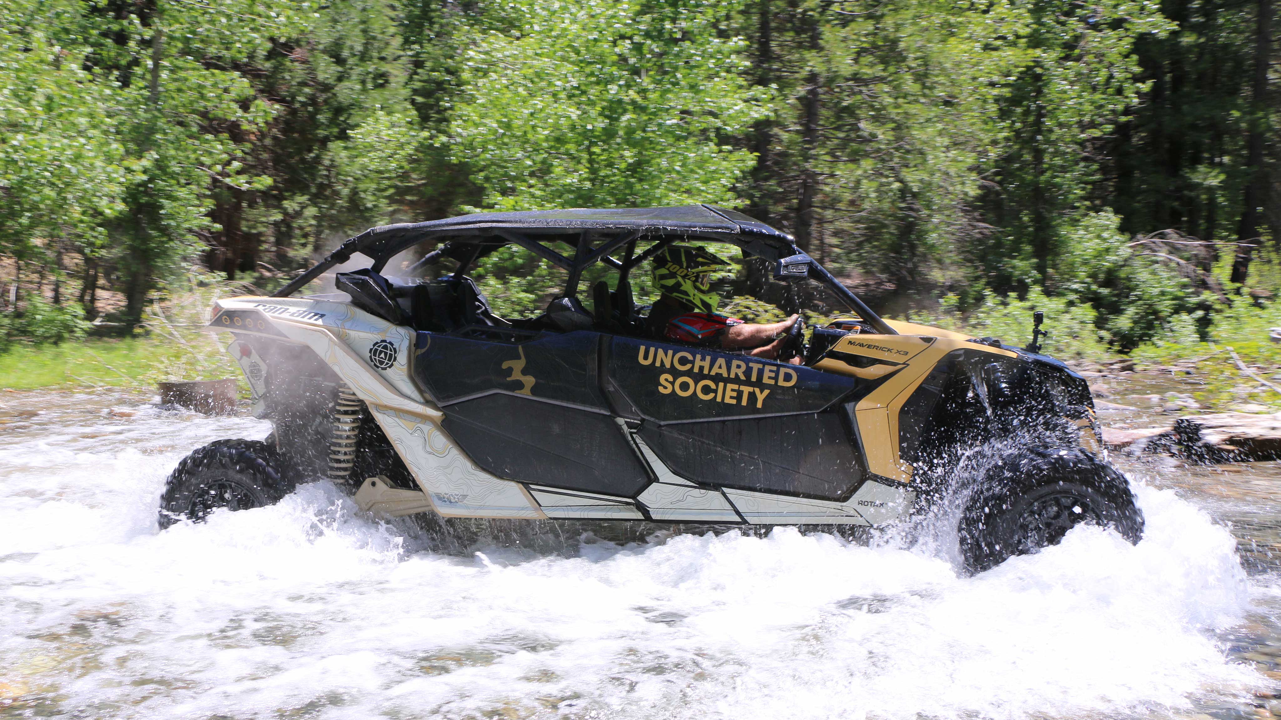 A rider driving a Can-Am through water