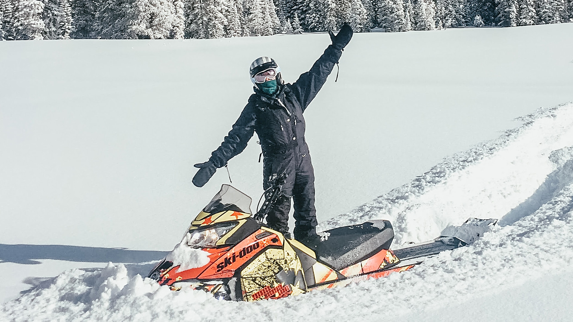A rider standing next to a Ski-Doo
