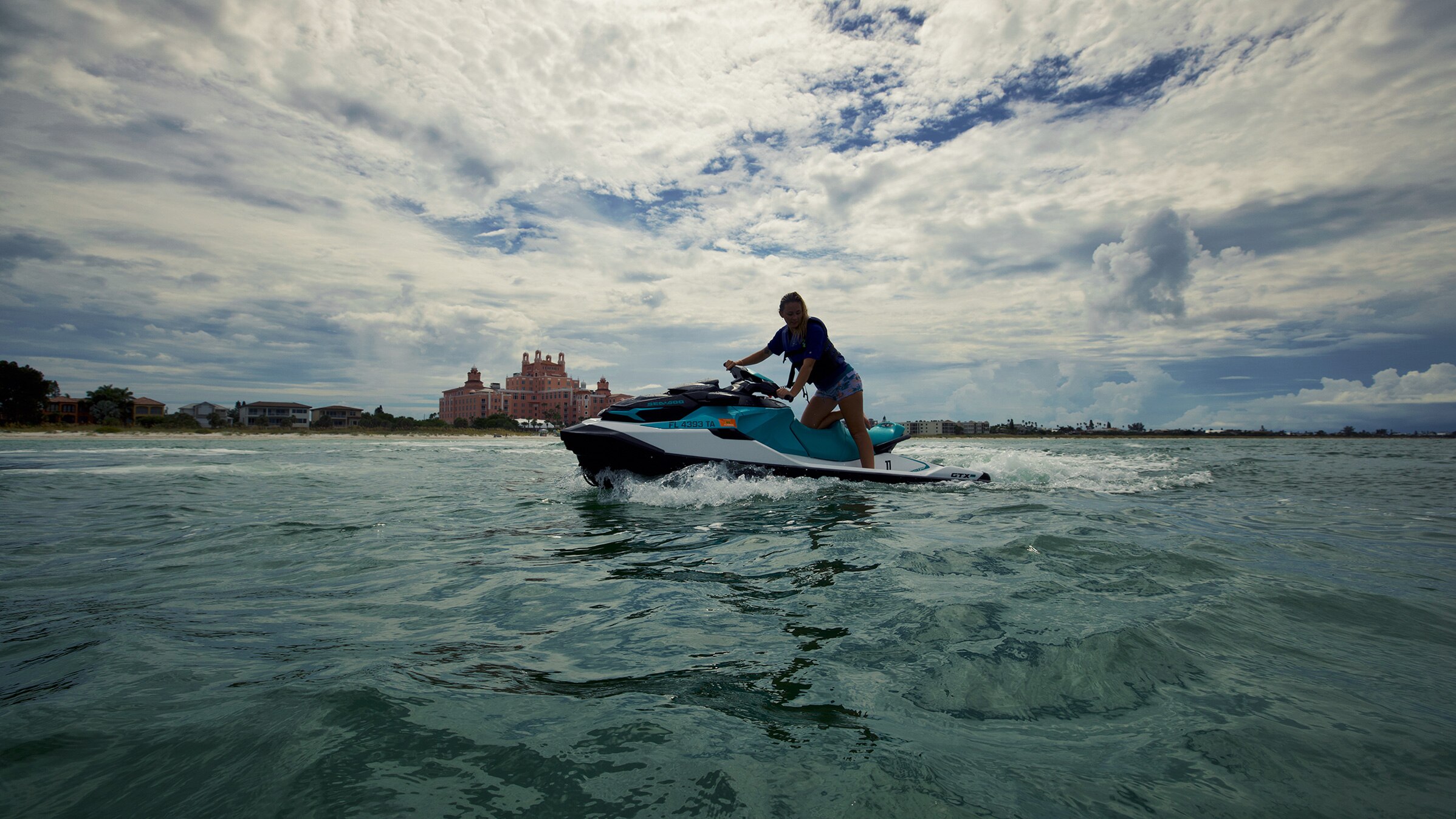 Une femme utilisant une motomarine Sea-Doo sur l'eau.