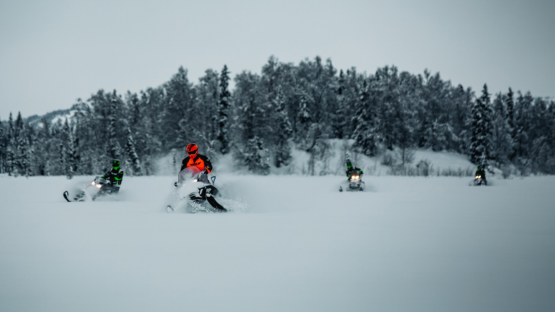 Group of four Ski-Doo riders in snowy landscape