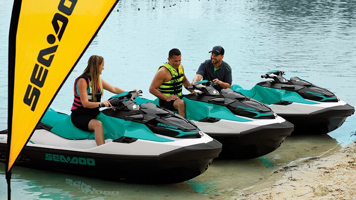 A couple and an instructor on Sea-Doo personal watercrafts