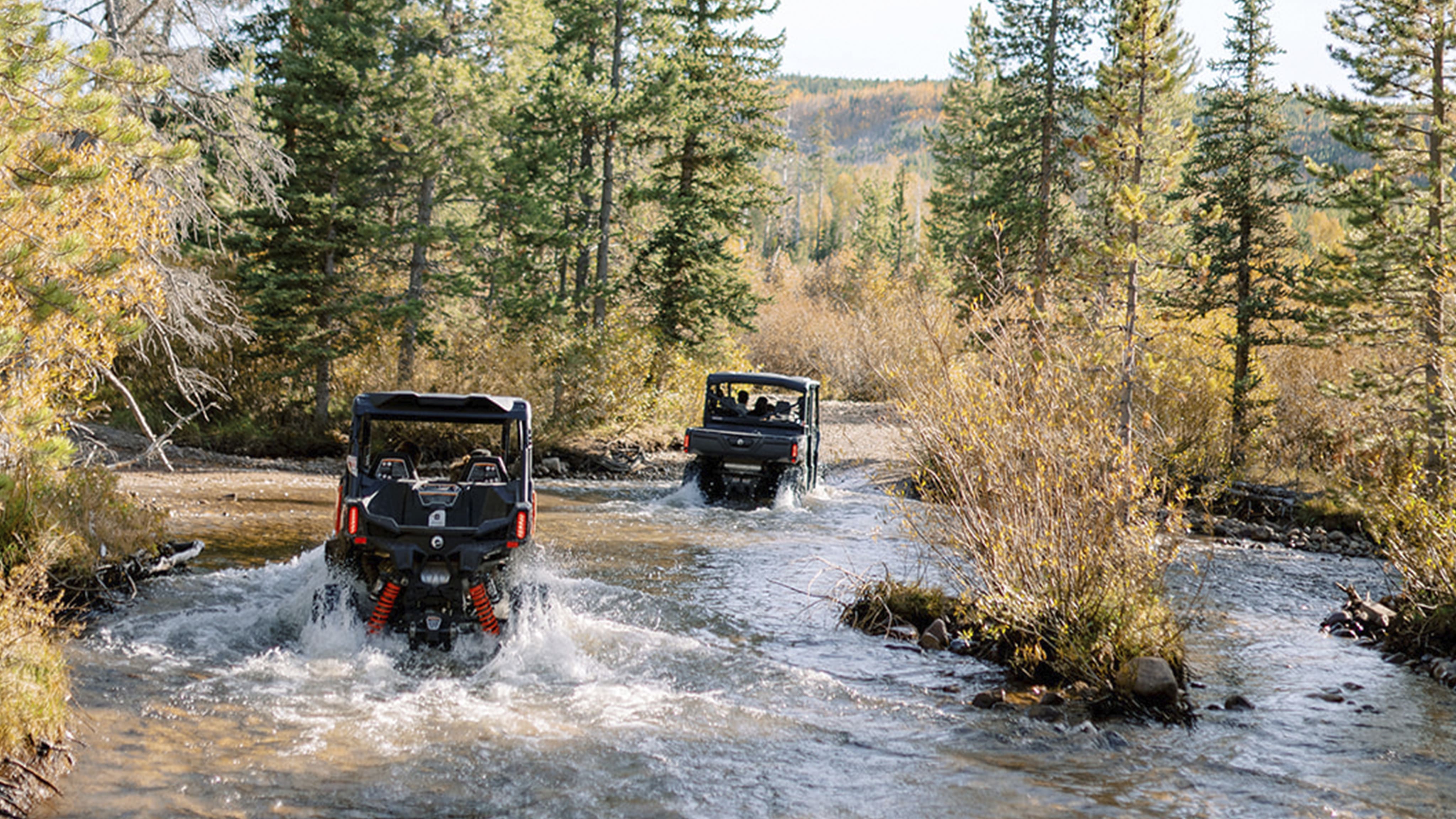 Two Can-Am Defenders driving in water