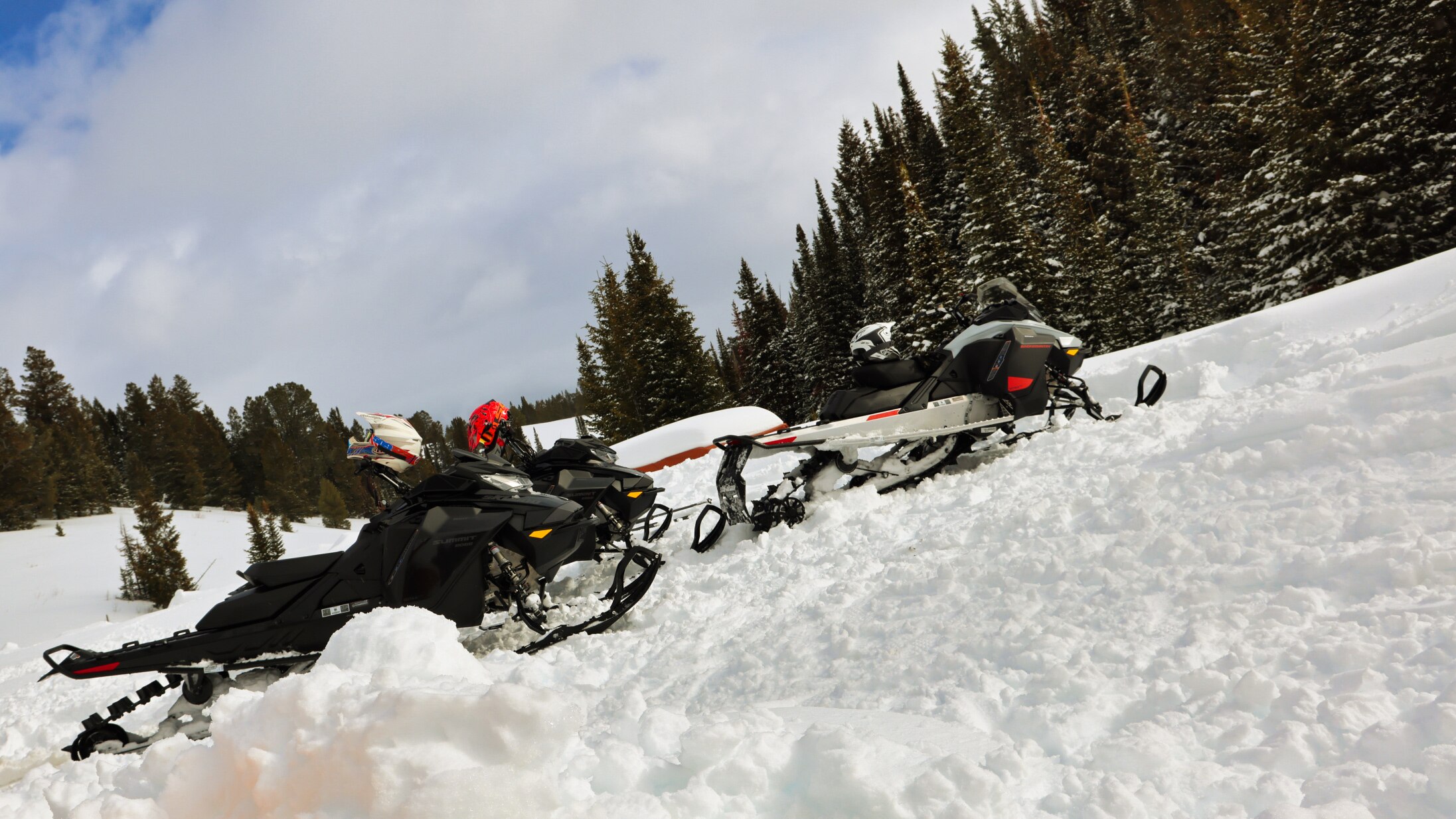 Two snowmobiles parked in the snow