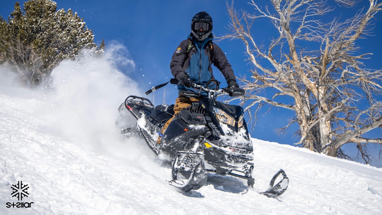 A man riding a snowmobile down hill