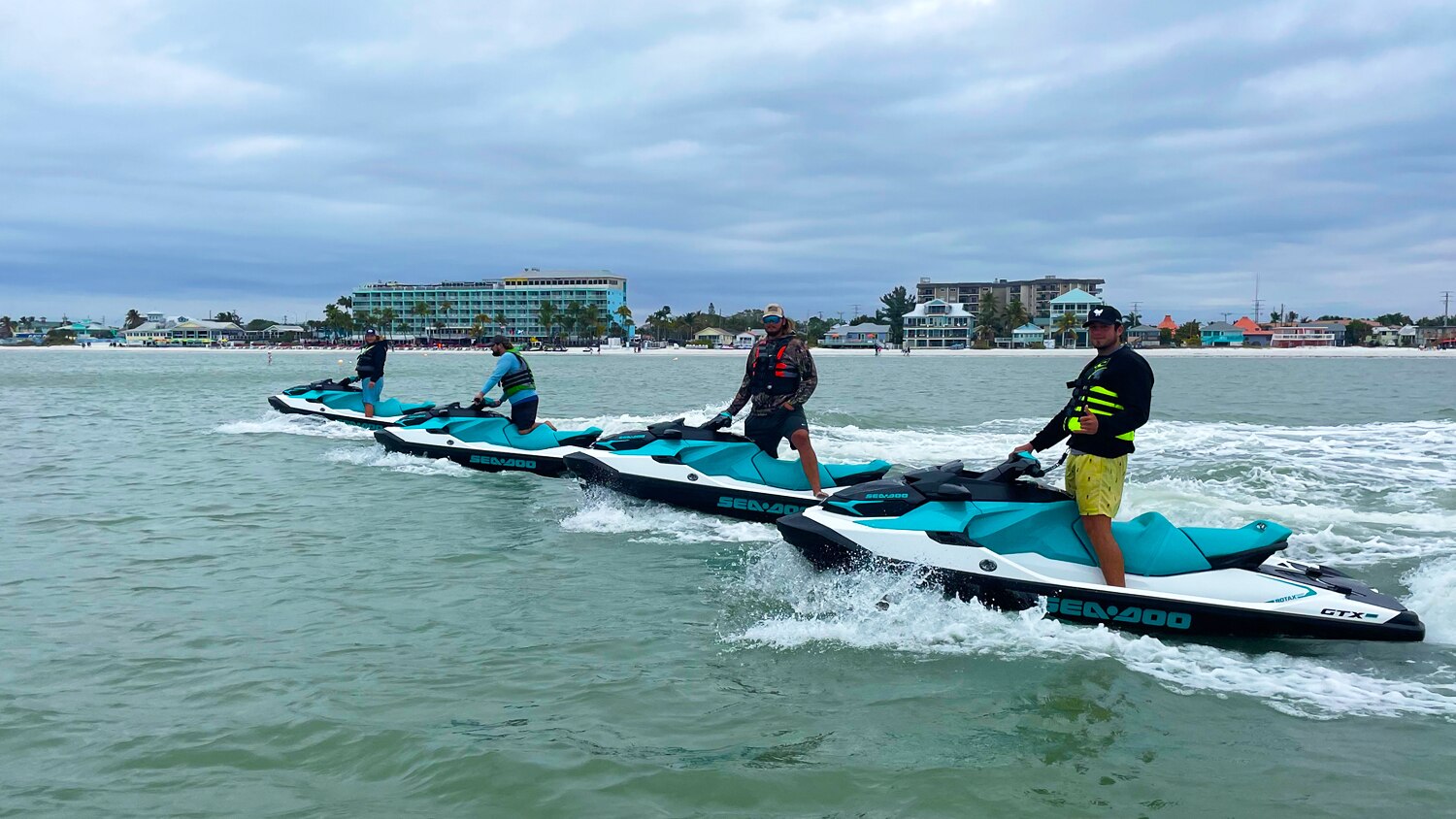 Vue latérale de quatre pilotes de Sea-Doo dans l'eau