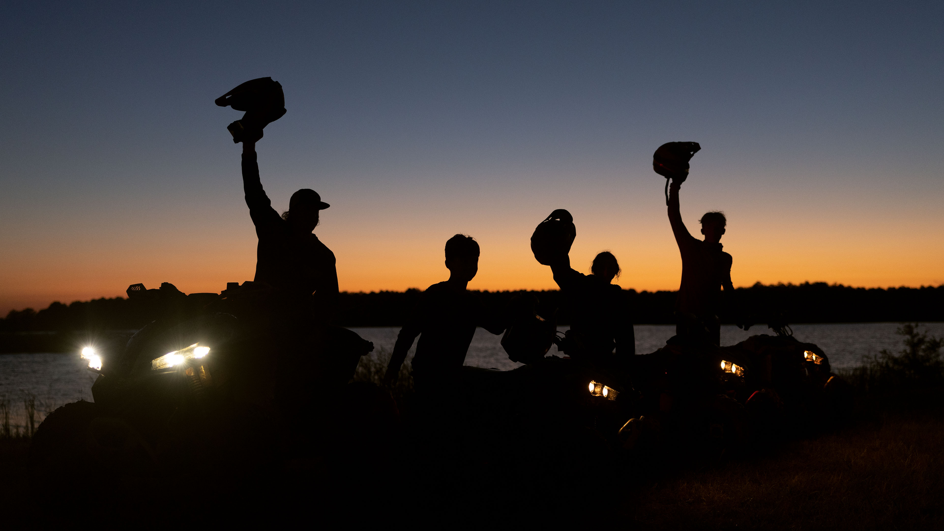 Des motards célébrant sur un UTV en regardant le coucher de soleil.