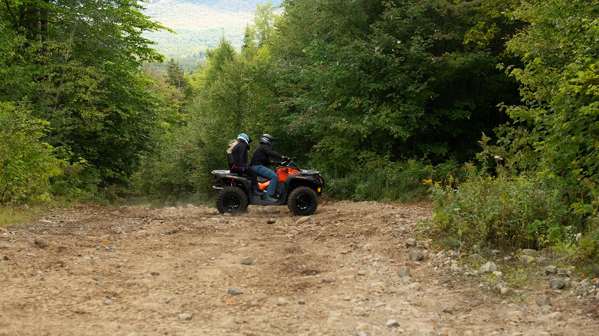 A couple on an ATV in the forest