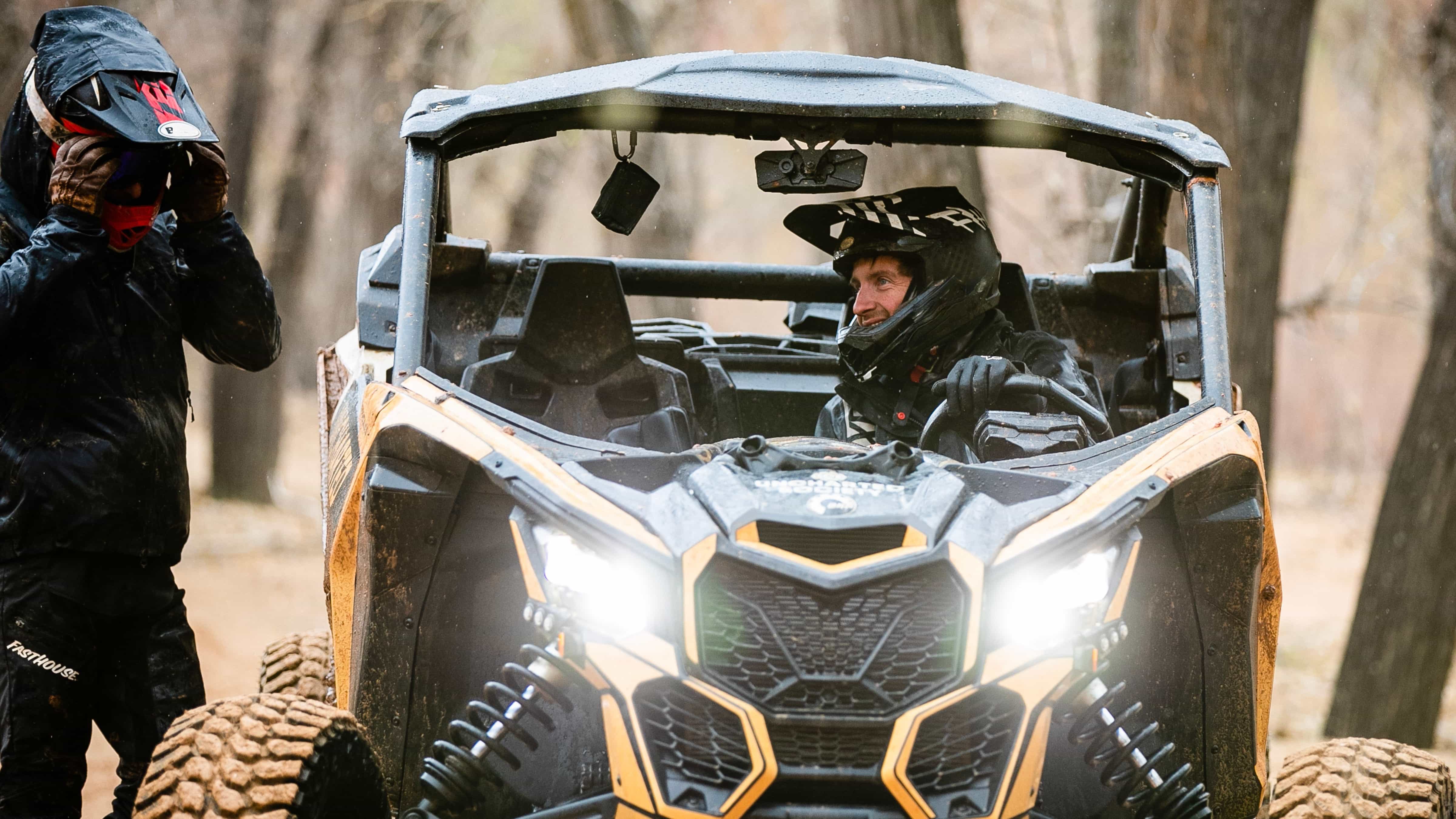 Two Can-Am ATV riding on a dirt road