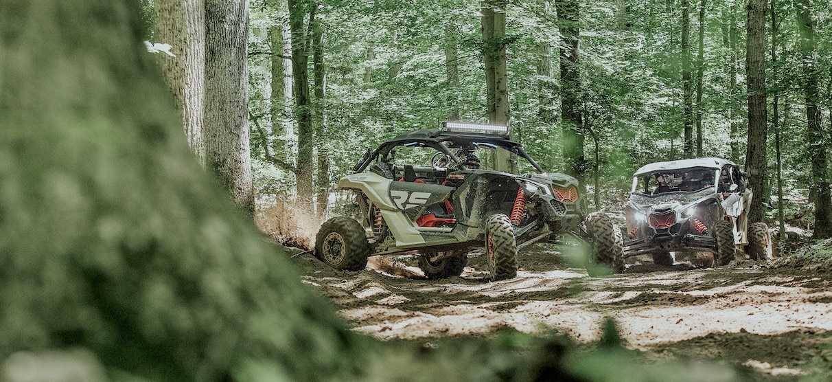 Two parked side-by-sides in the forest