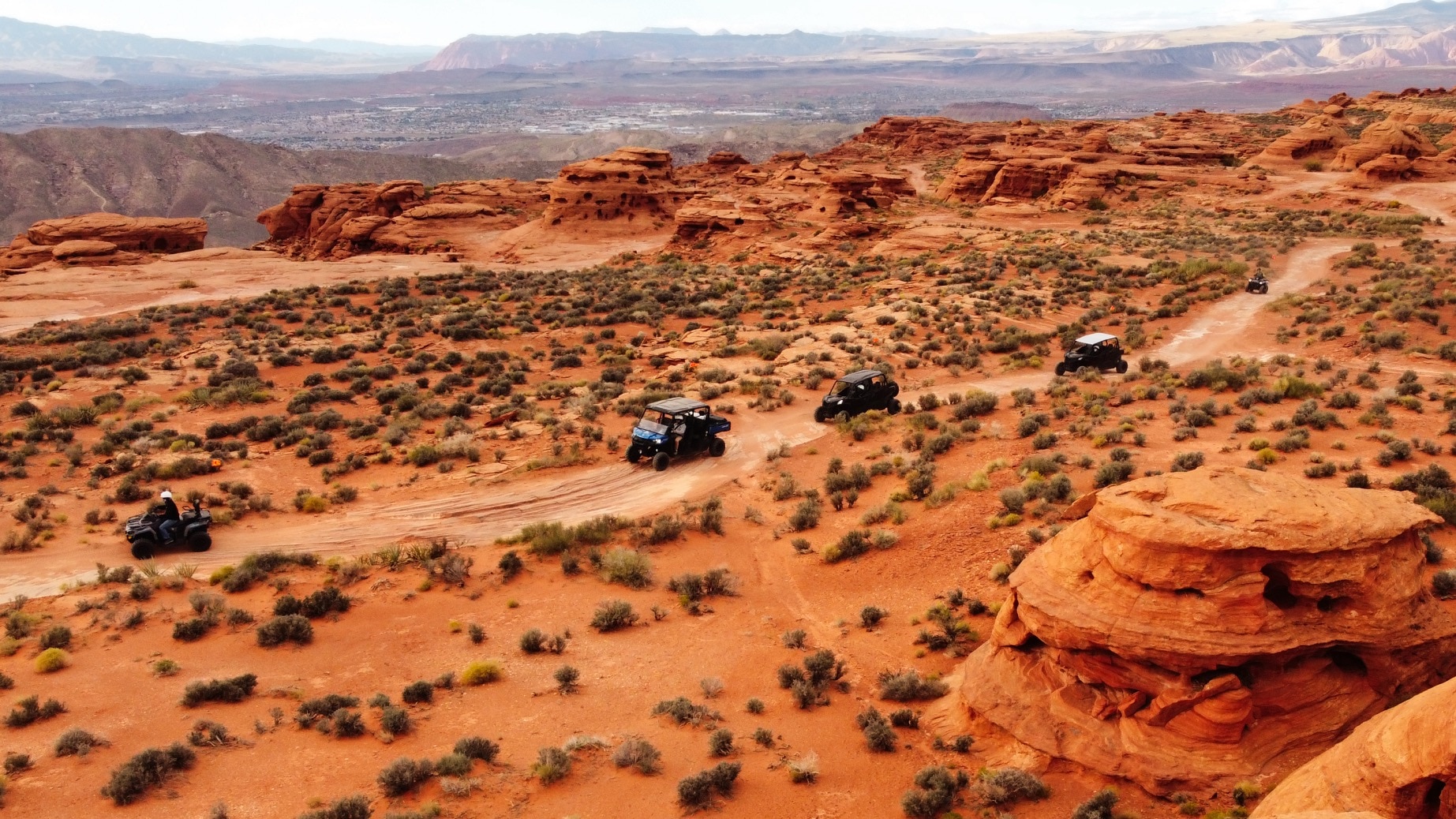 Bird eye view of a convoy of off-road riders driving in the desert of Utah