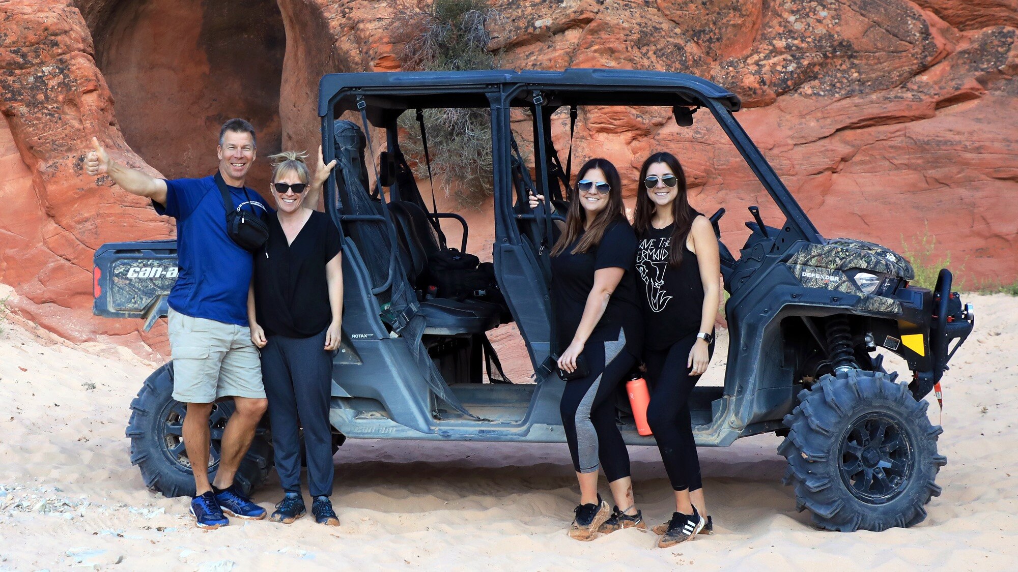 A group of people standing by a UTV in the Canyon