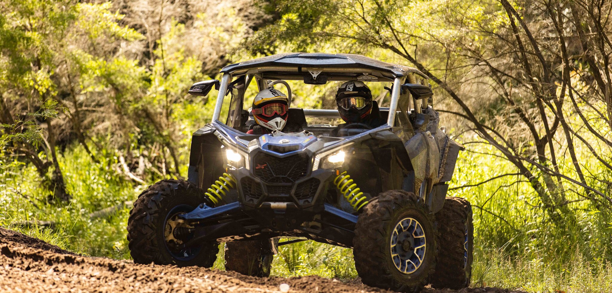 Two persons in a parked Can-Am Off-Road vehicle