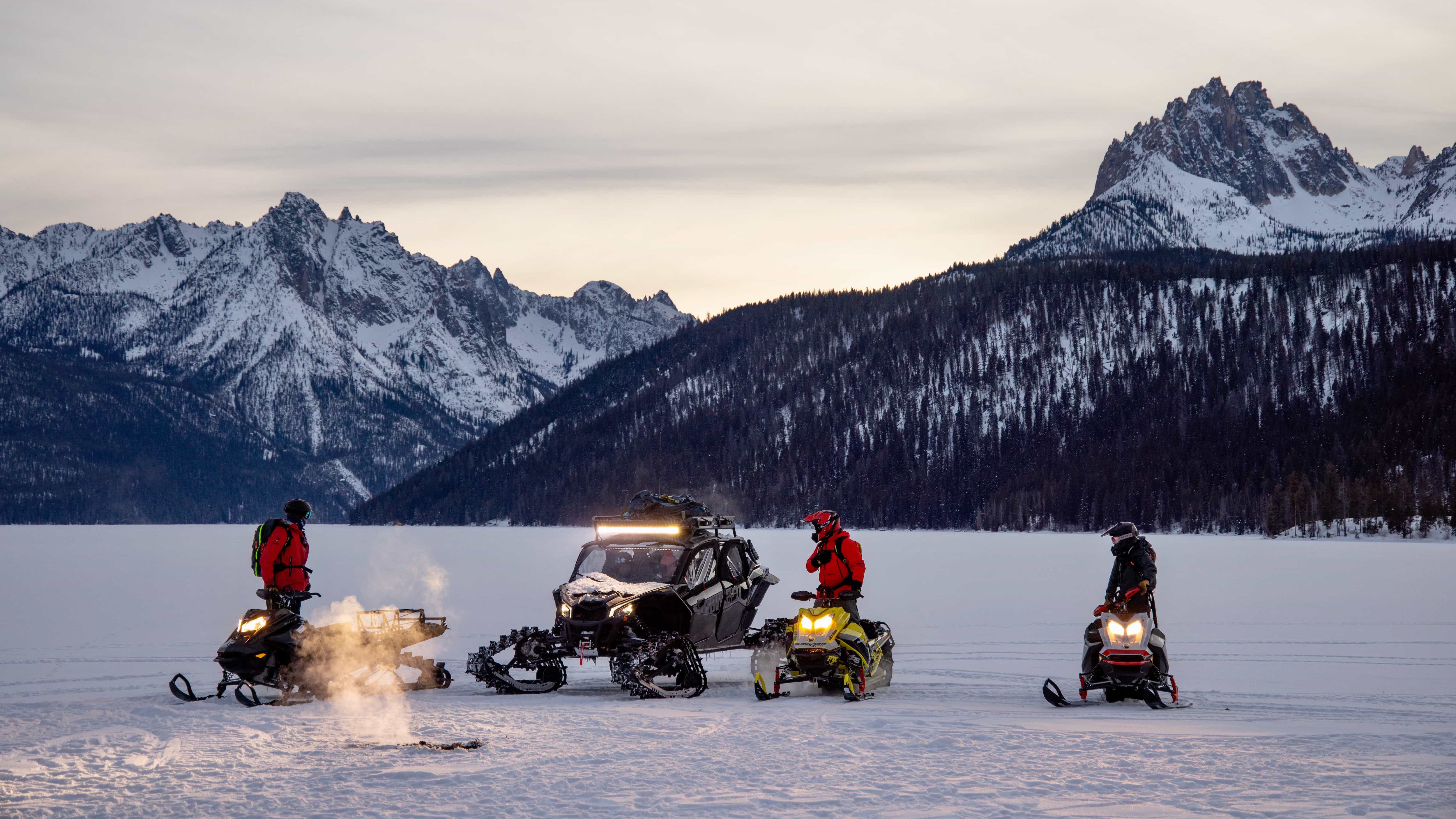 Snowmobiles and SSV around a campfire in winter