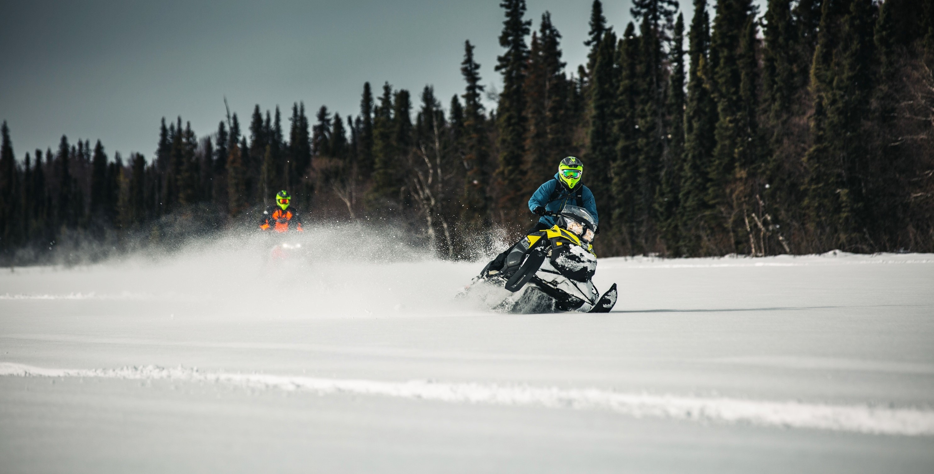 Two snowmobilers riding on a fresh snow in Utah
