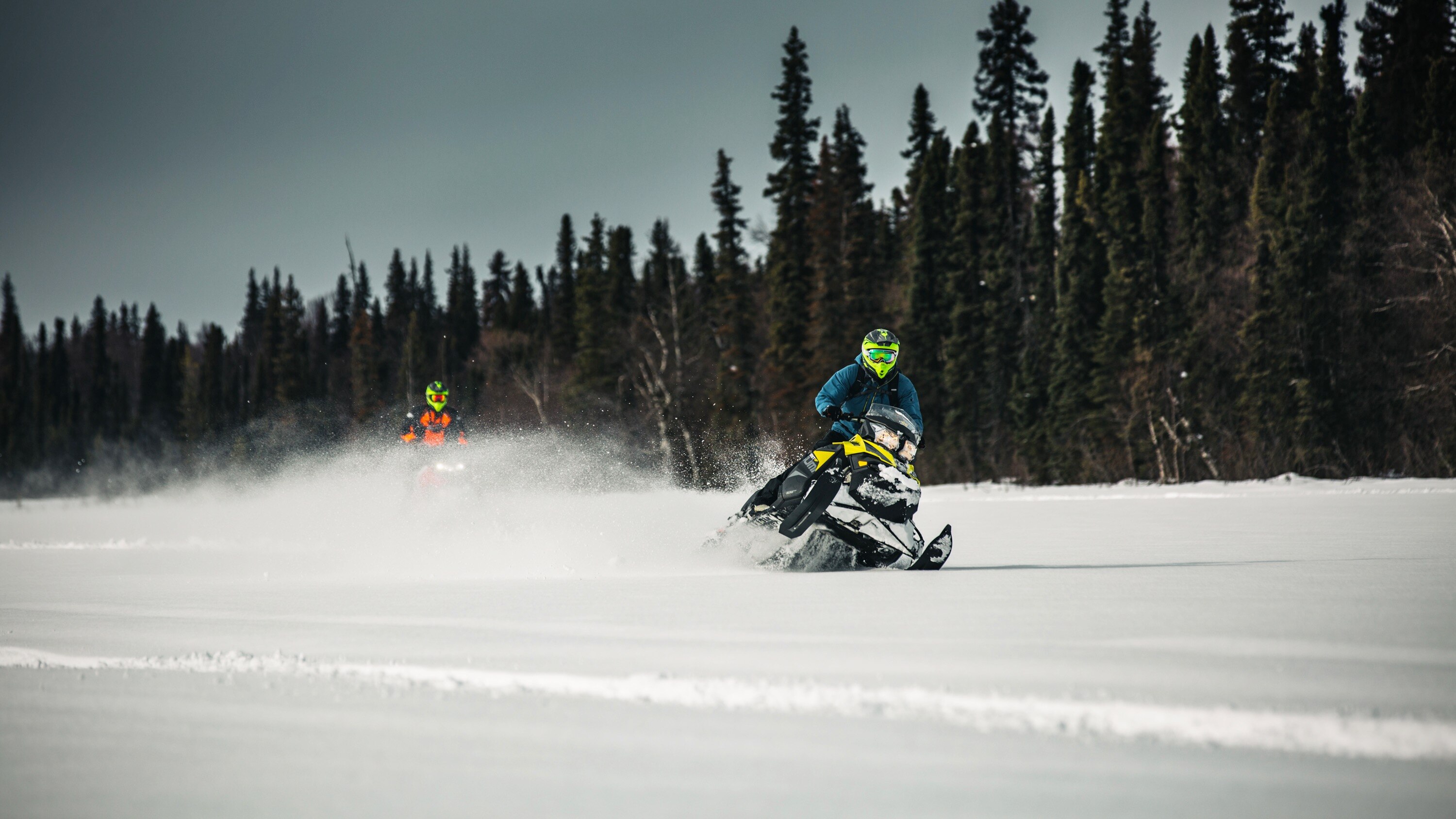 two ski-doo riders on a frozen lake