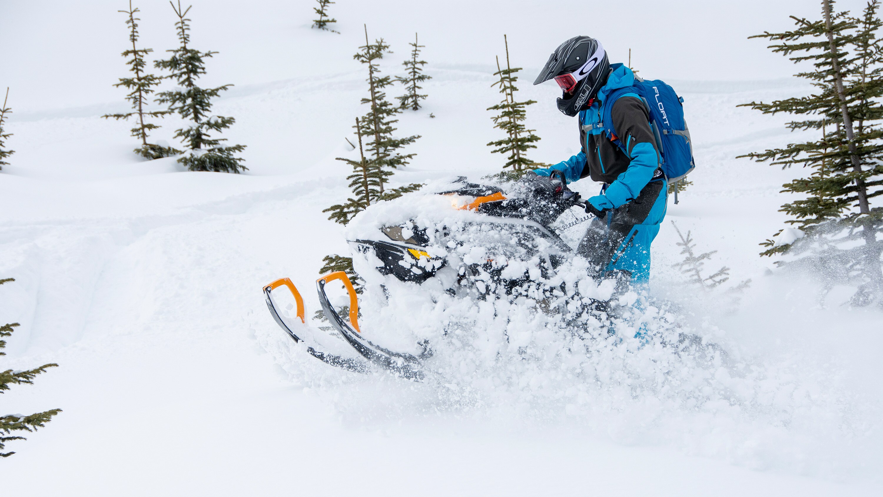 Off-trail snowmobiler turning in powder snow