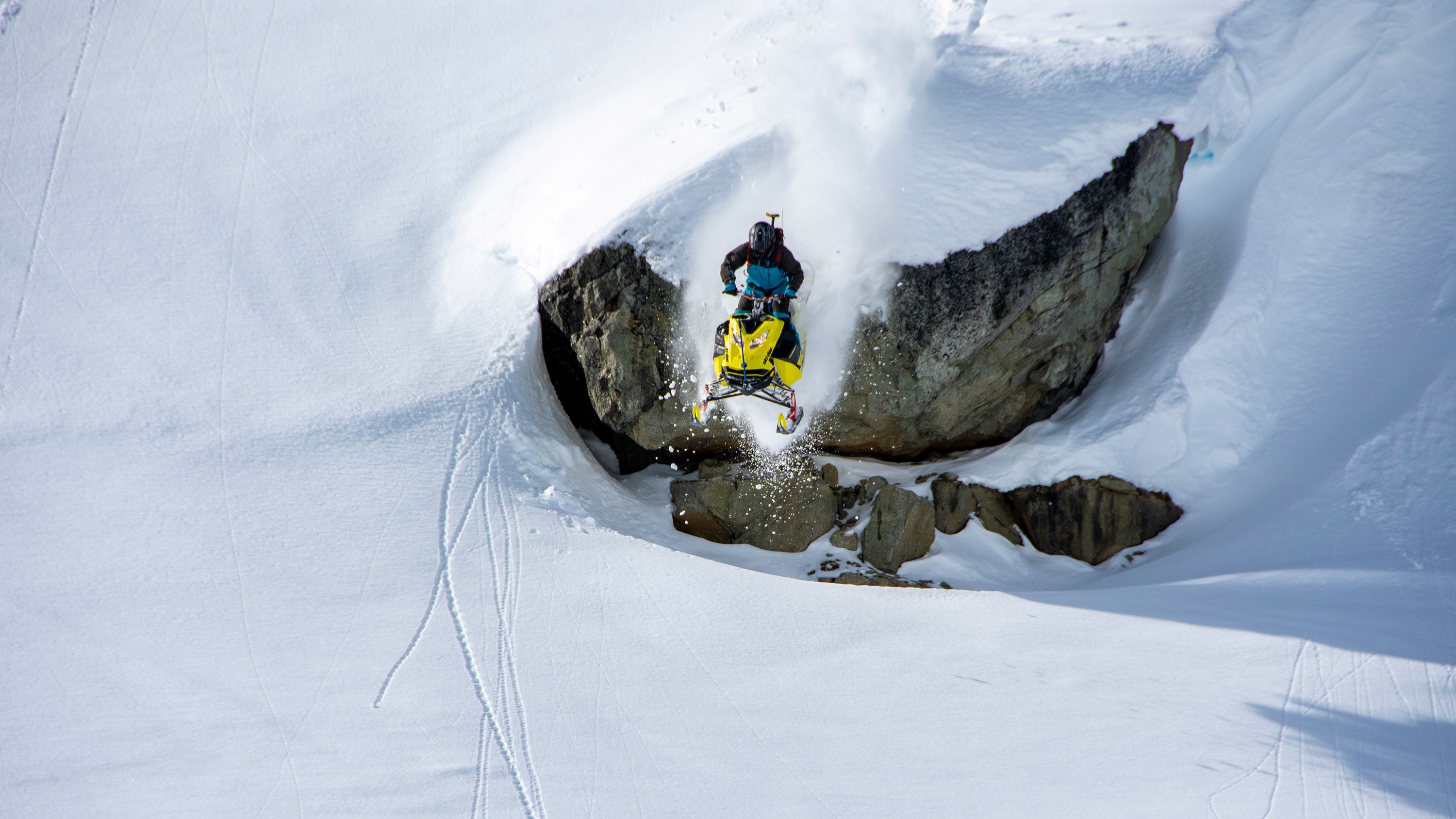 A snowmobiler executing a jump off-trail