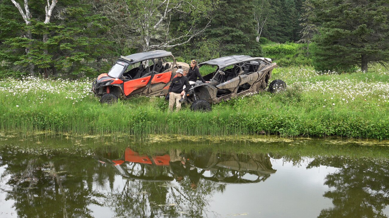 A Can-Am unit with a Canadian flag parked on a mountain with trees in the back