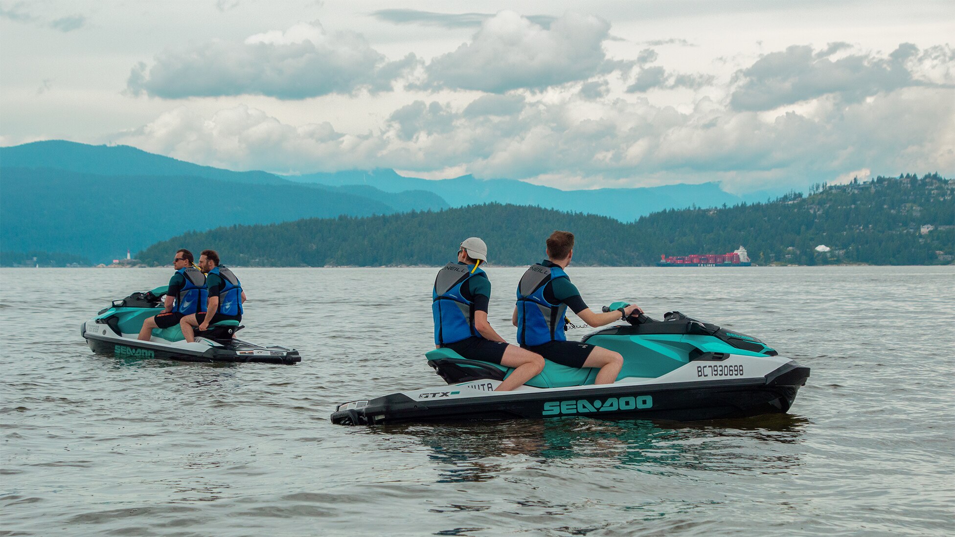 Hommes admirant les montagne sur des motomarines Sea-Doo