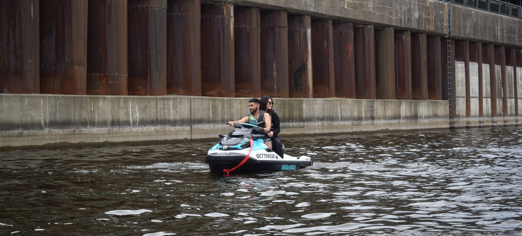 A couple on a Sea-Doo PWC with an industrial background