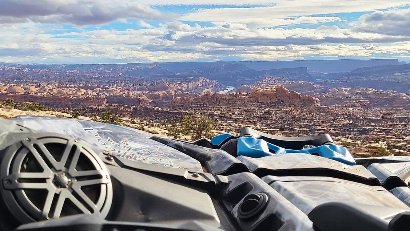 Can-am SVS vehicle looking over mountains with blue sky and clouds 